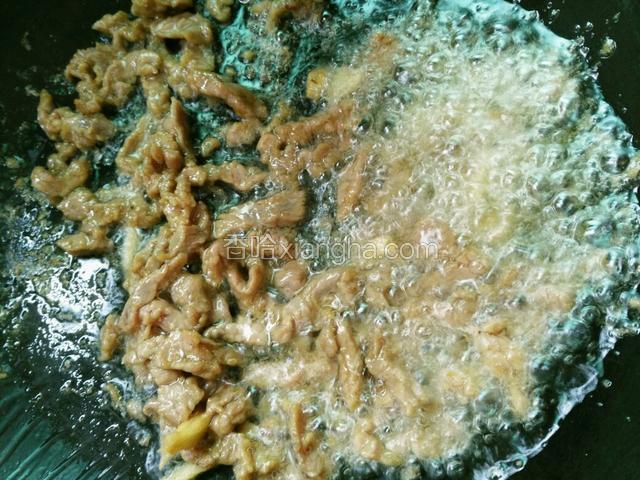 锅里热油，放入牛肉快速翻炒。