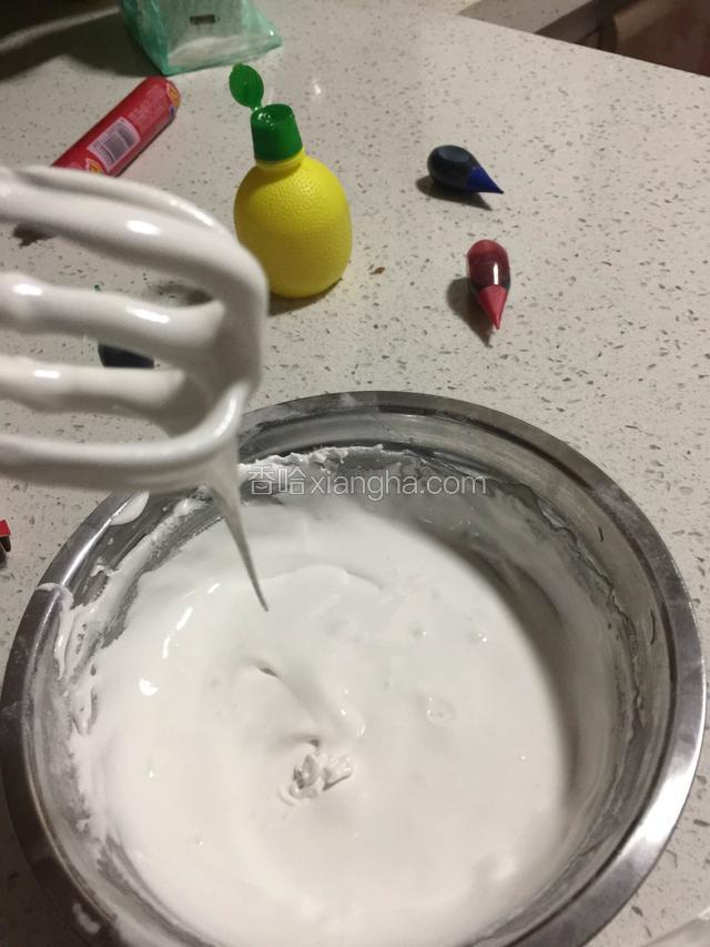 下面制作糖霜，蛋清打入无油无水的干净盆里，分次加入糖粉，用手搅打，直到全部糖粉都混合均匀，加入数滴柠檬汁，如图这样，可以拉线但还不是很细很长！打出来的糖霜是光滑细腻的才对
