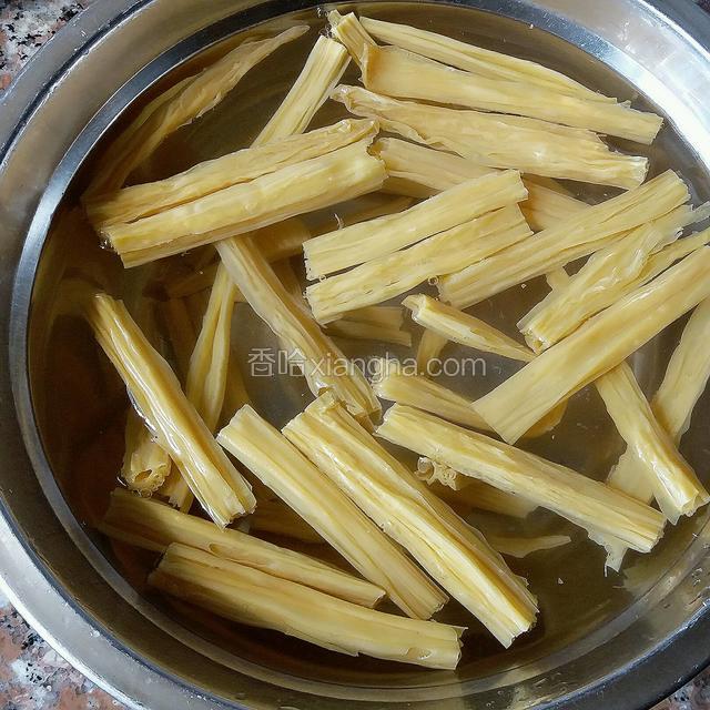 接下来，把腐竹折成长短均匀的段后用温水泡发