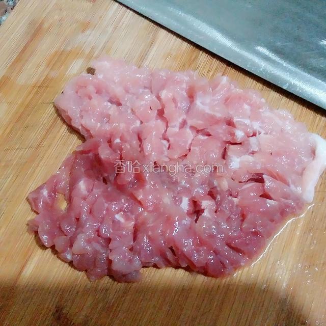 接着把准备好的肉剁成肉末，先从一面横着切片，再竖着切，也就是十字花刀，这一面不要切断，再反过来切另一面，同样的十字花刀，这一面切断，这样剁肉末快而省力