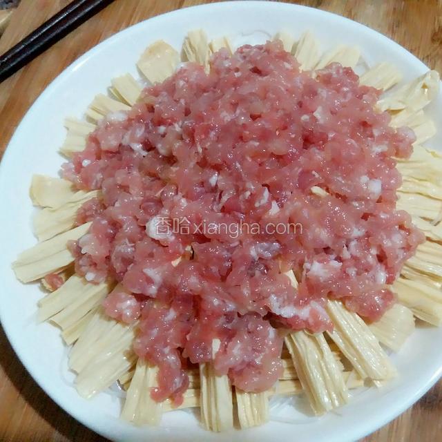 再把腌制好的肉末也均匀的铺在腐竹上。