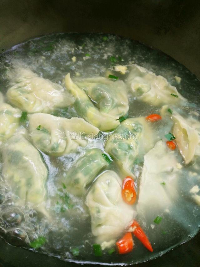 水烧开后放入水饺，盖锅盖煮。加一次冷水，再煮三分钟左右。放入辣椒，生姜。