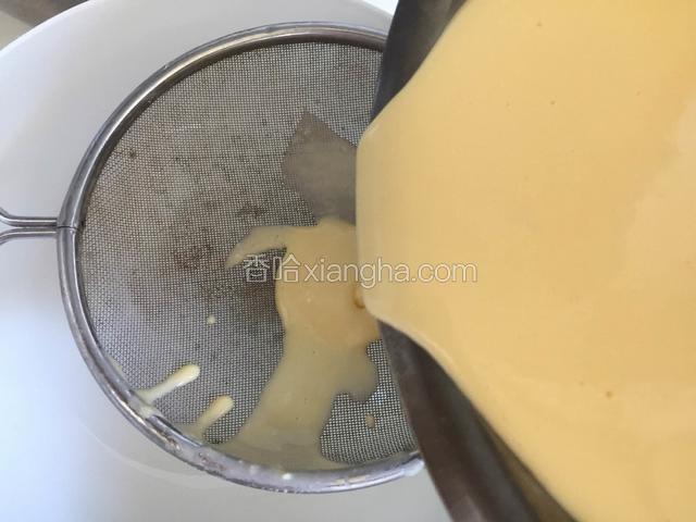 把搅拌均匀的蛋黄糊过筛，一共过两次筛，有漏不下去的用刮刀碾压一下，直到所有的糊都过筛，然后再重复一遍。