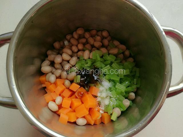 把沥干水的胡萝卜，芹菜和花生米放在盆中，加入盐，耗油，酱油，鸡精和香油。