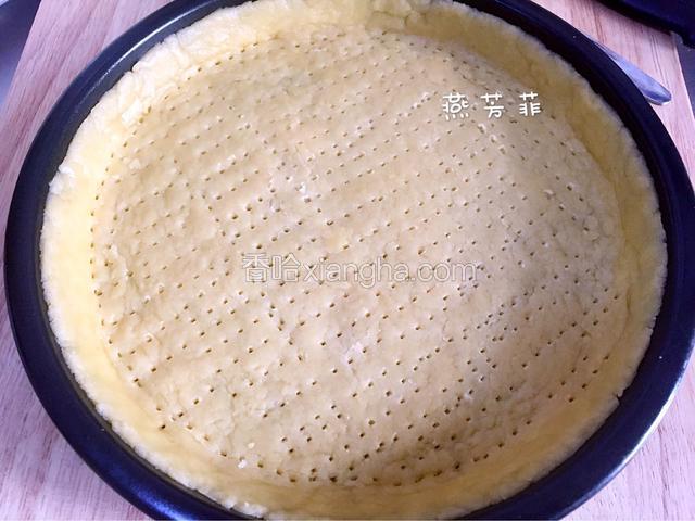 放在盘中，把四周多余的皮卷起来翻边。用叉子在饼皮上扎上小孔。
烤箱180度预热。