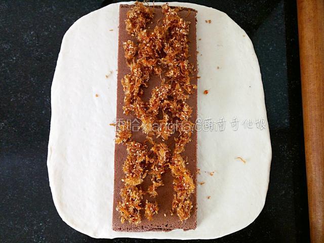 放入一个蛋糕块在中间，铺上一些辣肉松。
肉松是随意的，你们可加可不加，如果要加的话就肉松40g和沙拉酱18g放容器里拌匀即可。
蛋糕夹心可以是原味蛋糕、可可蛋糕或抹茶蛋糕或其他任意自己喜欢的口味。
我这里用的可可戚风蛋糕，为了使整个菜谱更直观简洁，我把蛋糕的做法放最后面了，从步骤21开始。蛋糕可以提前一天制作，也可以在面团揉好后利用一发的时间来做，时间上大家根据自己的情况随意安排。
