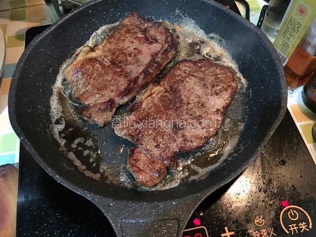 牛排一面煎好后再翻另一面煎，每面大概两分钟左右