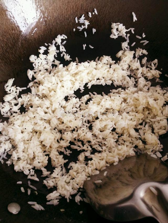 如果油剩不多再加一点葱油，倒入米饭中小火快速翻炒至粒粒分明
