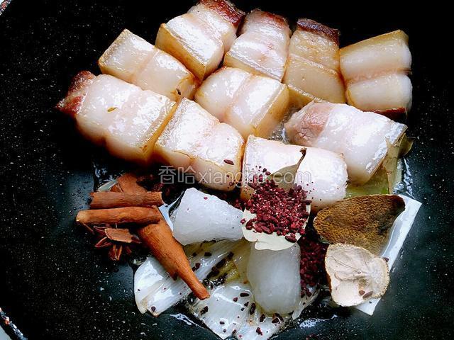 改成小火，把准备好的桂皮，陈皮，八角，冰糖，红曲米和香叶倒入锅内。