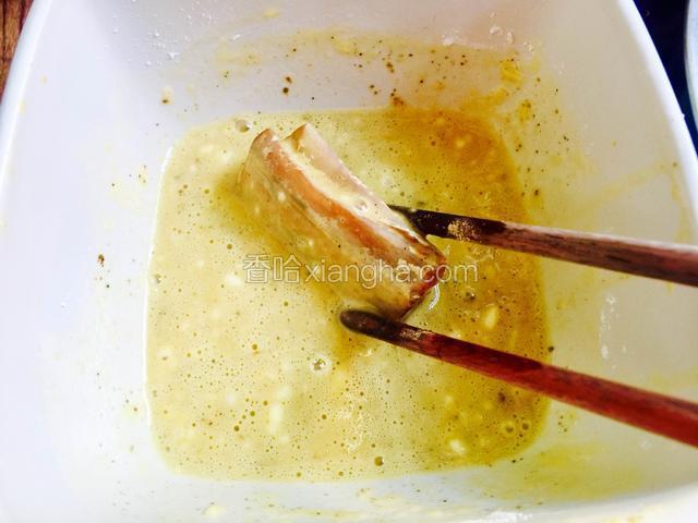 把腌好的带鱼段放在鸡蛋面糊里裹均匀。