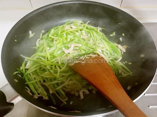 然后放入青萝卜丝，炒去萝卜的辣气。