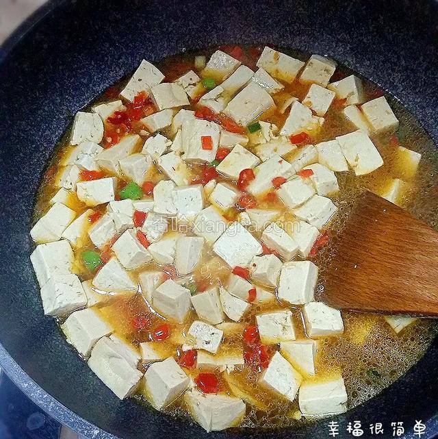 这时候，豆腐锅已经煮沸，倒入炒好的剁椒酱，放适量白糖，改中小火，再煮三分钟左右使其入味，最后再放入适量的鸡精。
