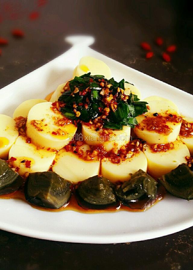 将豆腐码在盘子里，摆上皮蛋韭菜，再浇上调料