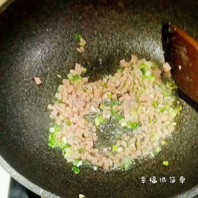 锅中加入适量的清油，下葱花放入午餐肉丁煸炒。