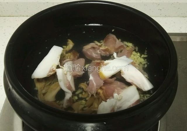 砂锅里加入冷水、腊肉、河蚌肉、姜粒，大火煮开。
