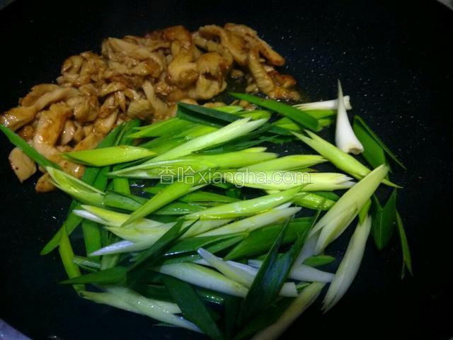 看鸡肉变色，铲到锅的一边放蒜苗段入锅非常