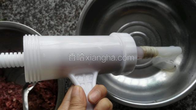 灌肠器是卖家送的，将肠衣套在上面底端打个结
，可以先挤入一点肉馅，这样在套肠衣的时候就非常顺滑了！