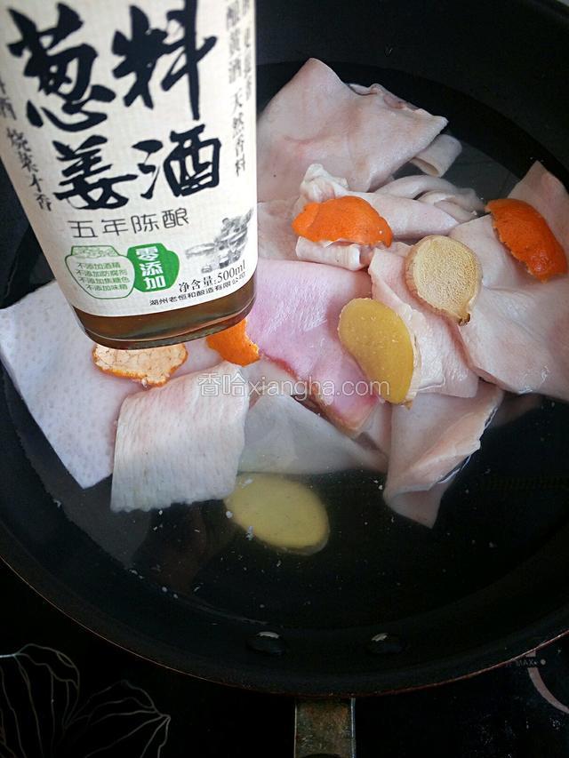 锅内倒入冷水放入处理好的猪皮，再加入姜片、陈皮和料酒去腥味。