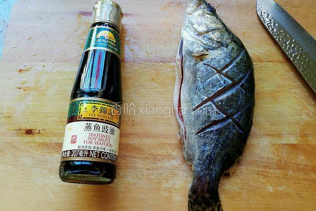 准备好李锦记蒸鱼豉油。将鱼清洗干净，打上菱形刀花。
