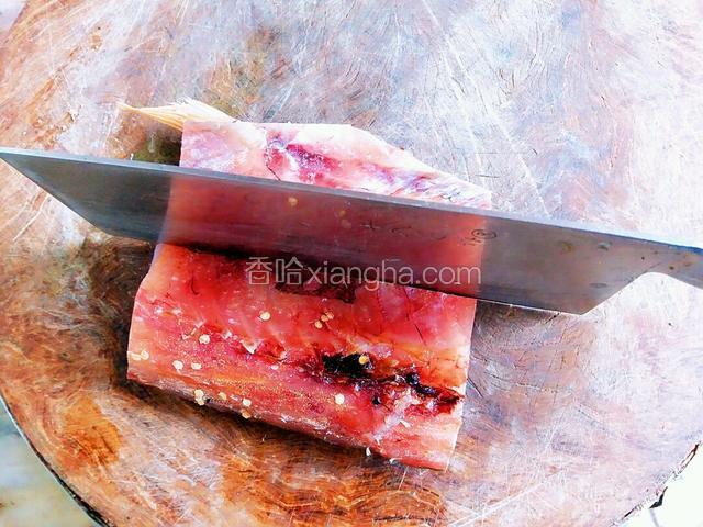 用刀在案板上把腊鱼一分为二