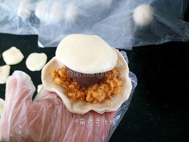 放上肉松，再放一颗豆沙蛋黄，最后放麻薯。
这里的肉松可以随个人喜好放3-5g肉松，我一般抓一把铺上。
麻薯在第二次擀卷好利用松弛的时间，把麻薯用刮板根据个人喜好分成约10-18g每个，共16个。麻薯会有多余。