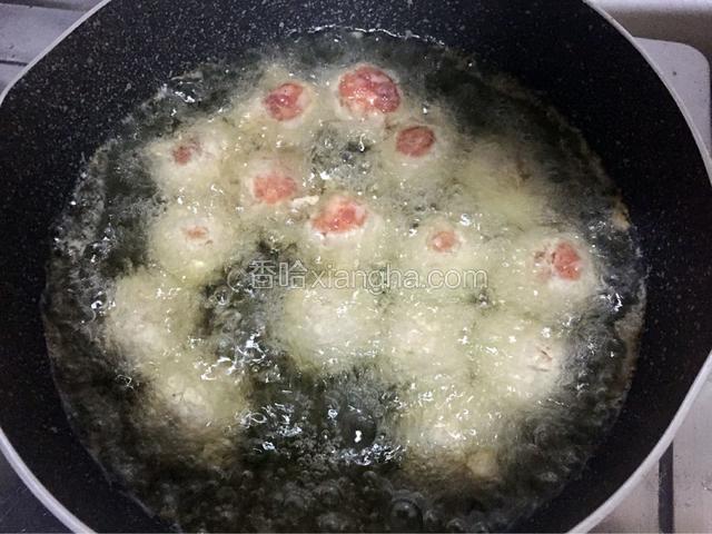 锅中倒入适量油烧至五成热时放入丸子，小火炸至金黄色