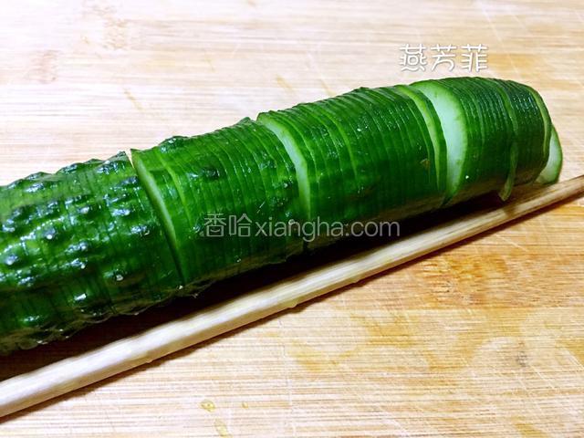 黄瓜洗干净控水。在黄瓜的两侧各放上一根筷子，从头菜刀90度、瓜片宽2mm切到最后。