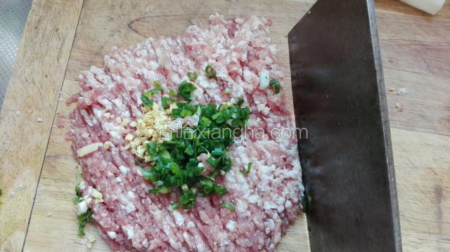 猪前腿肉加入姜末和葱粒，用刀剁成细肉泥。