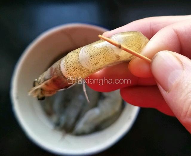 在虾壳第二节处用牙签把虾线挑出，然后再把虾须和虾枪剪掉。