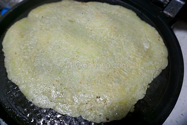 加热至一面凝固，之后翻面，待两面均变为焦黄色即可盛出。