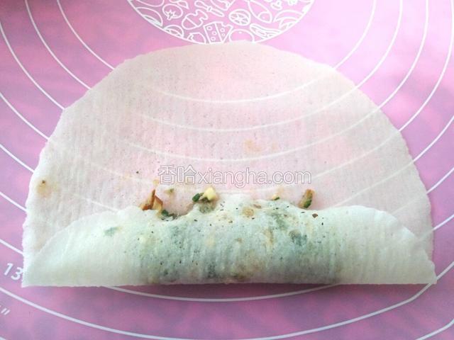 取一张春卷皮，放入适量的荠菜馅，从里往外卷一道(如图)