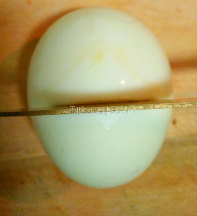 将八个鸡蛋煮熟扒皮，取一鸡蛋大头在后，小头在前。在四分之三处用刀横切，不要切到蛋黄。