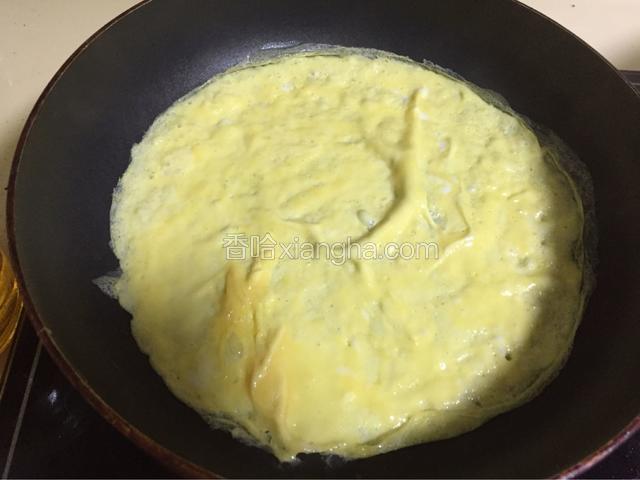 开始煎鸡蛋饼。
平底不粘锅烧热了以后滴入玉米油涂抹均匀，离火倒入鸡蛋液小火煎至两面熟。
饼的厚度在2mm左右。如果不好掌握，厚一点没有关系的。