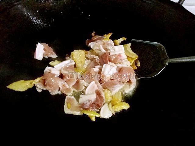 起油锅，放少量油，放入鸡皮炸炸油，爆香蒜末和姜丝，倒入肉片炒香，放少量盐调味。