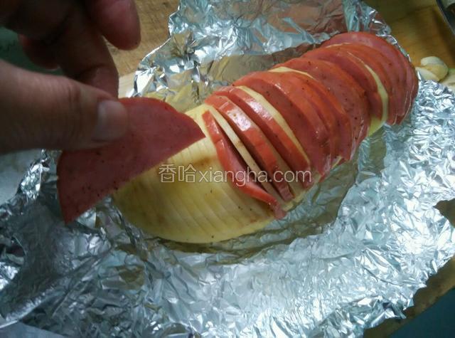 拿出土豆，依次夹上火腿片，再撒上盐和胡椒粉，入烤箱210度烤15分钟即可