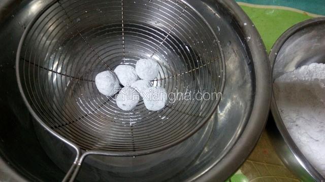 将蘸粉的馅料放在笊篱中迅速蘸水