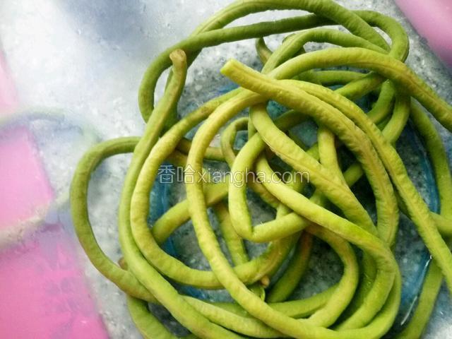 锅里放水烫开放入豇豆煮软。