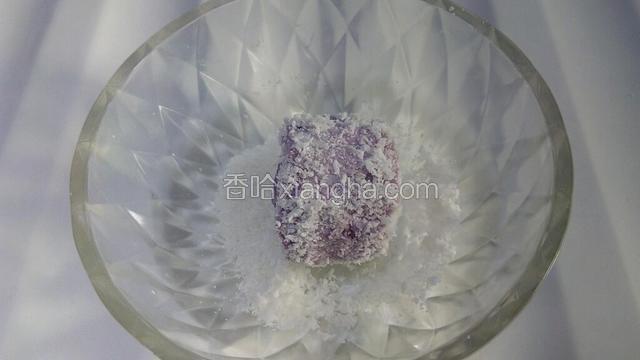 从冰箱中取出模具，倒扣，取出做好的小糕点，在盛椰蓉的碗中滚几下，使其沾满椰蓉。