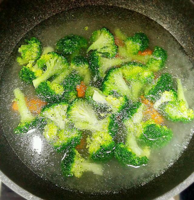 洗净后的西兰花和胡萝卜，放入开水中焯一下，倒入适量的油，这样颜色会更漂亮。