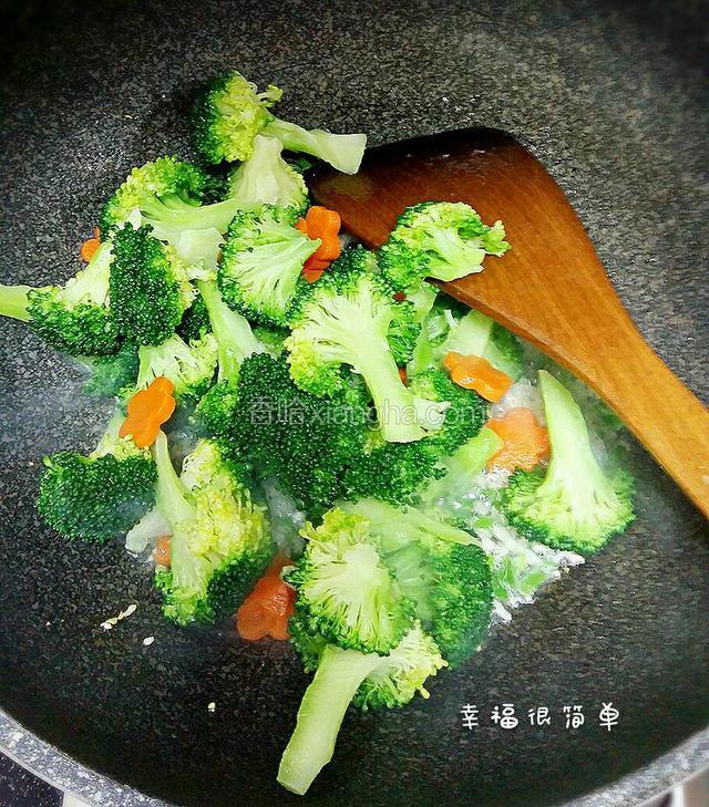 快速地煸炒西兰花和胡萝卜放入适量的盐，糖。