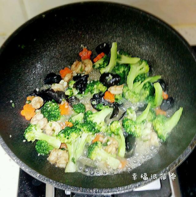 一两分钟后再烩入之前炒好的黑木耳和虾仁。快速的翻炒，加入薄薄的淀粉水，勾一下芡，放入适量的鸡精。