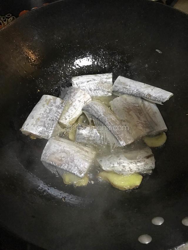 热锅冷油下 姜片 接着放入带鱼段 稍微煎一下 倒入料酒去腥 盐