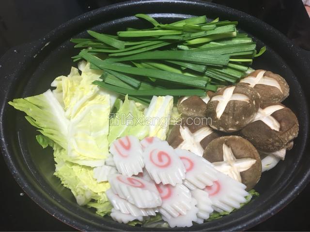这次我选择的垫底菜是白菜，把白菜平铺在锅底，然后把切好的蔬菜依次沿锅边摆放好。