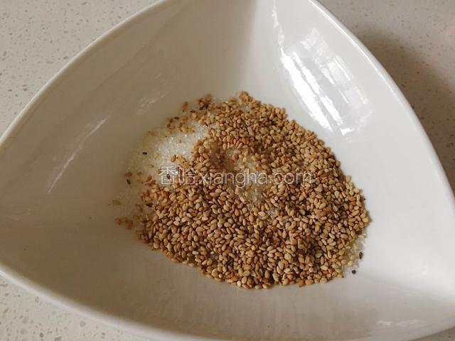 碗里放入芝麻和白糖。