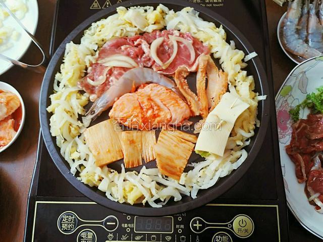 摆放很重要：
所有食材讲究条理分明，
中心温度最热。放不易熟的食物。
这个烤盘四圈是凹槽，最适合放吃油的菜。
位置很重要：
在凹槽和中心的位置放各式半成品或熟菜或易熟的菜。
这是平面烤盘，中心放油，易出油的菜放靠近中心地位置，为了让油可浸入其它菜，味道更好。

下图即按上面的方法布的菜品。