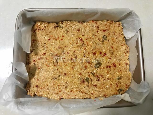 在方形烤盘中铺上烹调纸，这样就不用在烤盘里刷油了，也方便脱模。将混合好的食材均匀地铺在烤盘上，用硅胶刮刀处理平整。