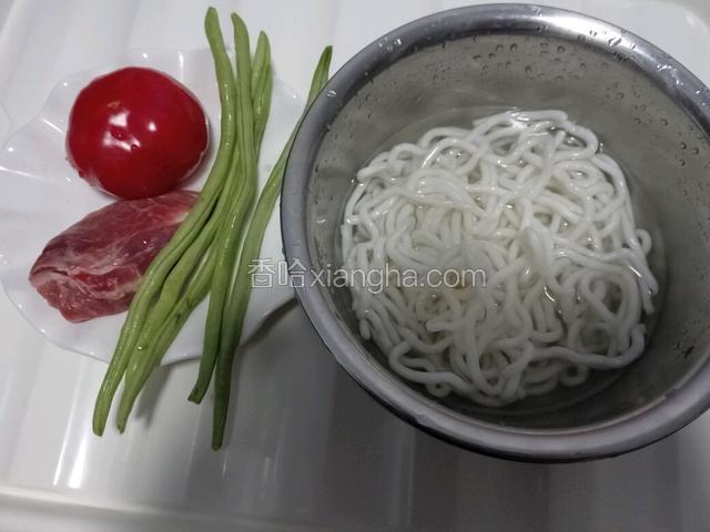 准备食材，将土豆粉用温水浸泡5分钟，将西红柿、豆角洗净。
