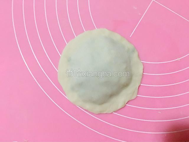再用一张饺子皮盖上，把周围压紧