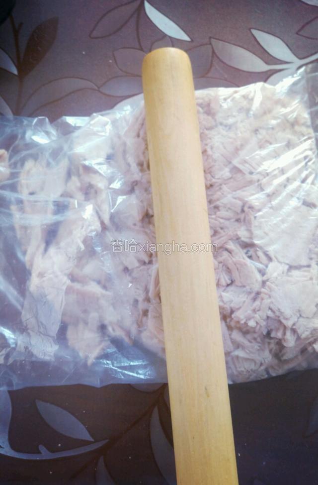 将晾凉的猪肉放入保鲜袋用擀面杖敲碎