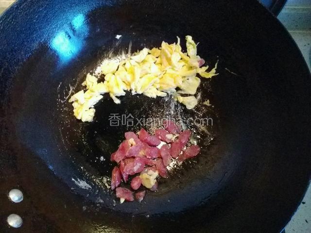 鸡蛋，用铲子切碎，腊肠儿煸炒至变色；